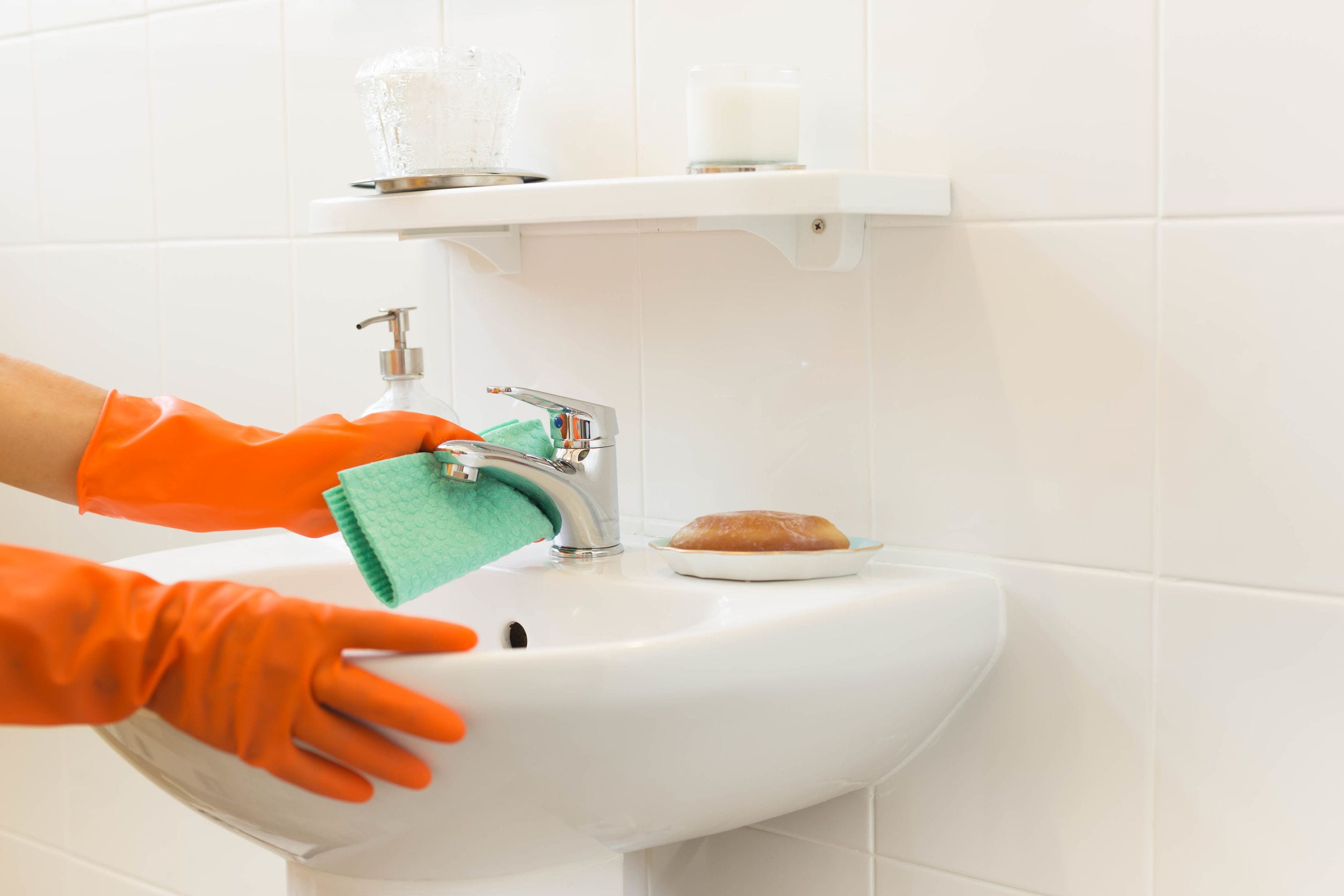 Woman cleaning water tap Woman cleaning water tap